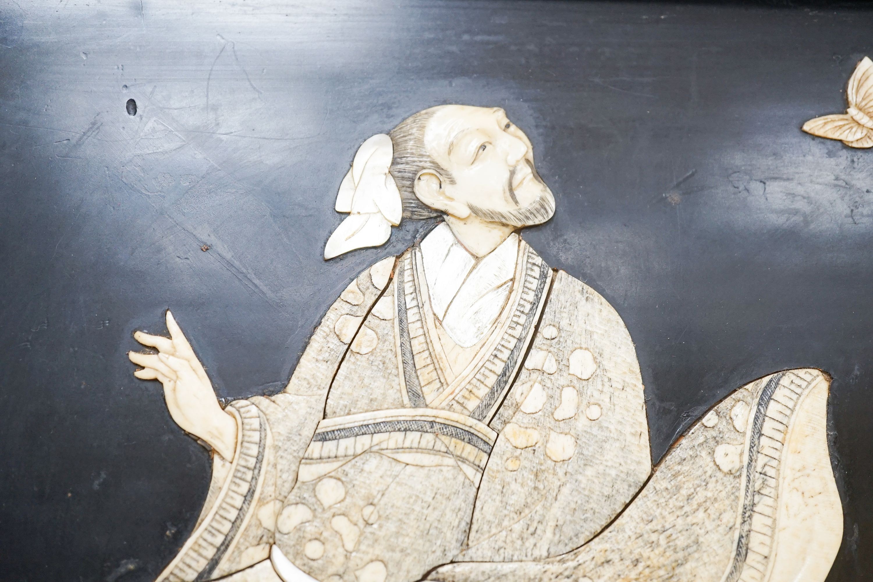 A pair of Japanese Shibayama style ivory, bone and mother of pearl inlaid lacquer panels, Meiji period, depicting two seated men, the other a bijin, 30 x 45cm